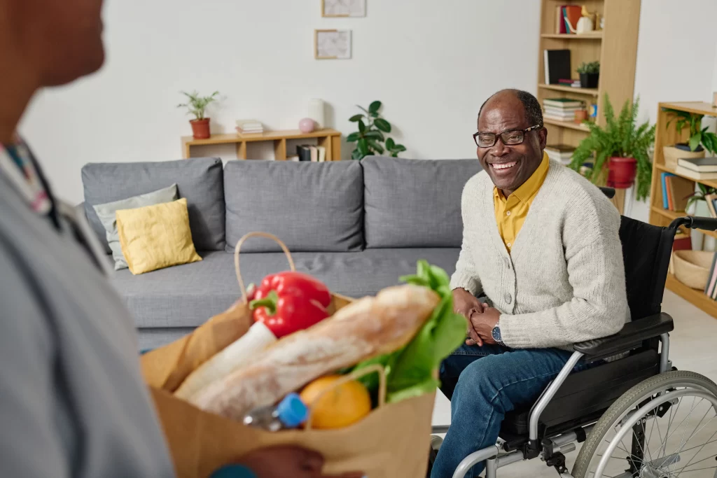 Man with disability getting groceries from caregiver